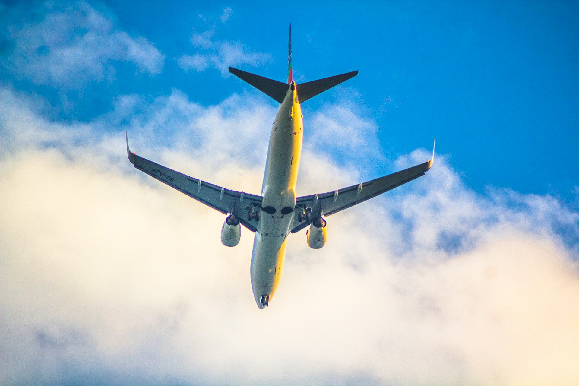 a large jetliner flying through a cloudy blue sky